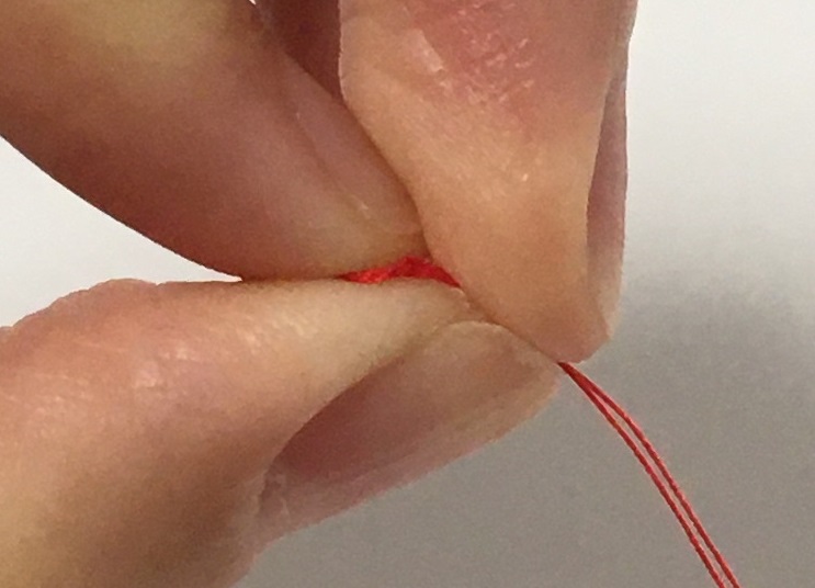 糸はねじったままで中指で糸を人差し指から抜く。